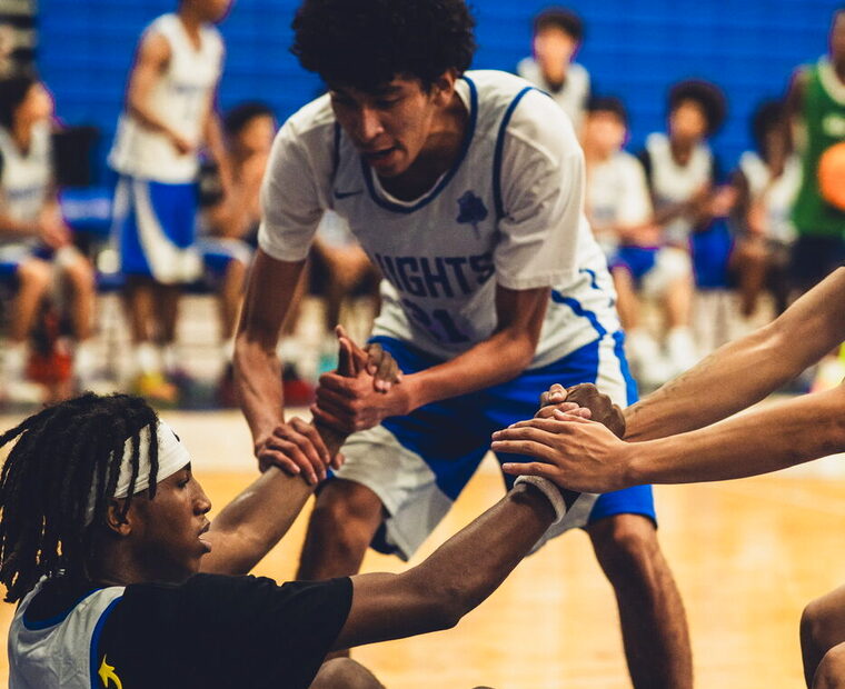 Westview Knights players pulling a teammate up off the floor